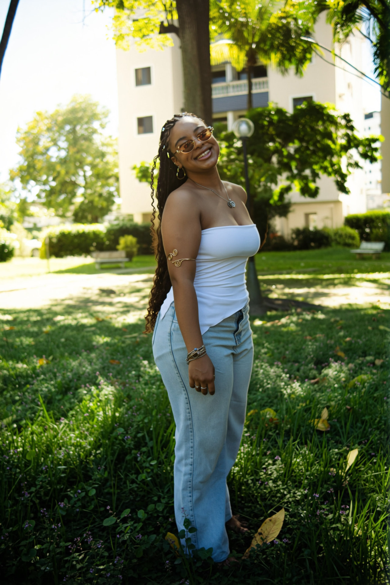 Ayla Montenegro ao ar livre, sorrindo de lado